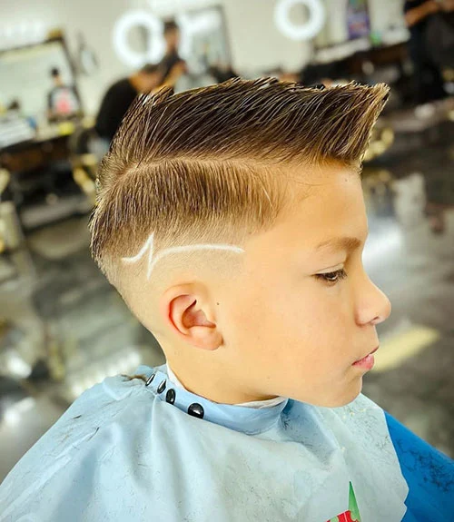 35 Popular Boy’s Haircuts Trending in 2025 (Cool & Stylish Ideas for All Ages) 26 This image has an empty alt attribute; its file name is Long-Side-Part-Fade-with-Design.webp